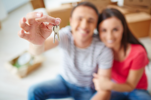 Hand of young man showing keys from new flat